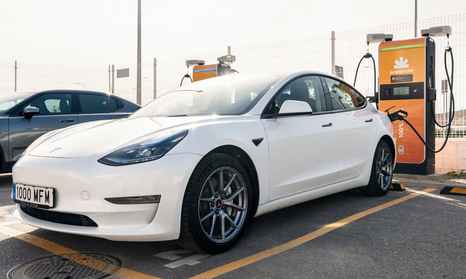 Un coche eléctrico en carga rápida conectado a un punto de recarga